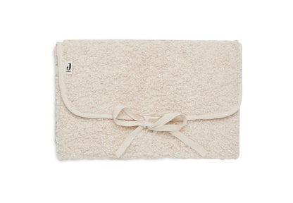Tapis à langer nomade en tissu bouclette naturel, plié avec liens